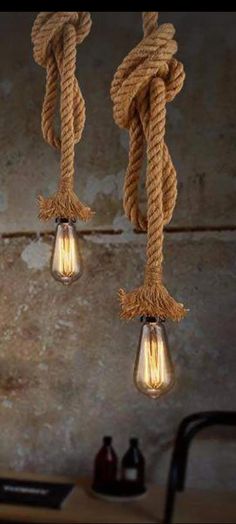 three light bulbs that are hanging from rope