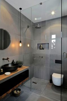 a bathroom with a glass shower door, sink and mirror on the wall next to it