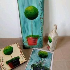 three paintings are displayed on a table