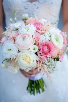 a bride holding a bouquet of pink and white flowers