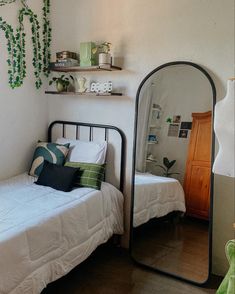 a bedroom with a bed, mirror and shelves on the wall next to each other