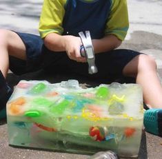 a young boy sitting on the ground with his skateboard in front of him,