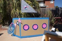 a cardboard box with some pink circles on it and a sailboat in the background