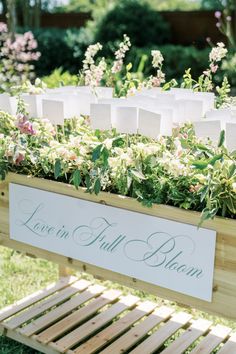 a wooden planter filled with lots of flowers