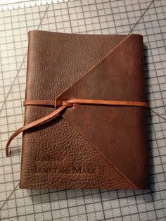 a brown leather journal sitting on top of a table