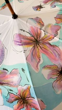 an umbrella with flowers painted on it is opened to show the inside of the umbrella