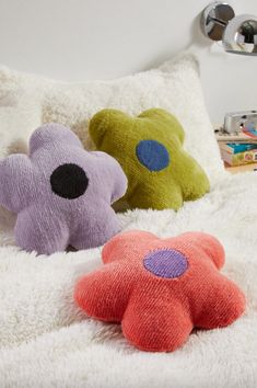 two stuffed animals laying on top of a bed next to each other in front of pillows