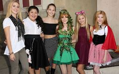 four girls dressed up in costumes posing for the camera