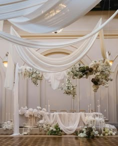 an elegant wedding setup with white draping and flowers