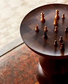 a chess board on top of a table with pieces arranged in the shape of people