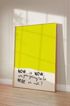 there is a yellow poster on the floor in front of a white wall with words written below it