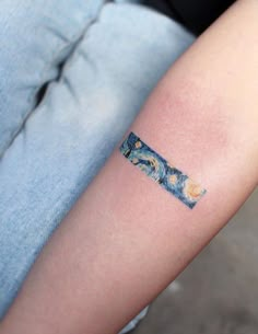 a person with a tattoo on their arm that has an image of the starry night