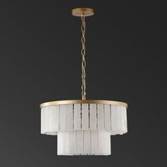 a chandelier hanging from the ceiling with white shades on it and gold trimmings