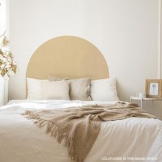 a bed with white sheets and pillows in a room