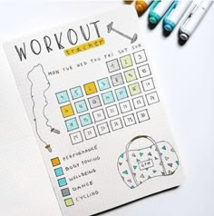 a notebook with the words workout written on it next to crayons and markers