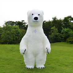 a large white polar bear standing on its hind legs in the middle of a field