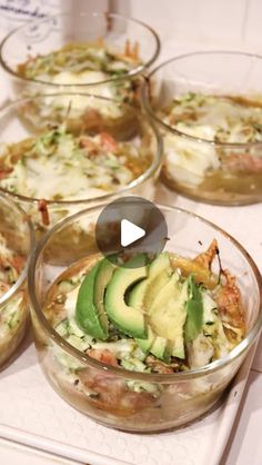 several glass bowls filled with food sitting on top of a white countertop next to each other