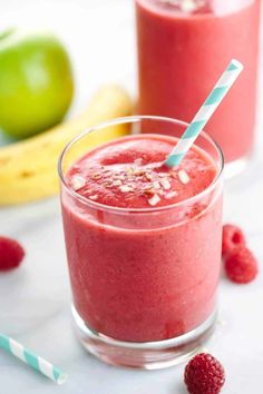 two glasses filled with raspberry smoothie on top of a table