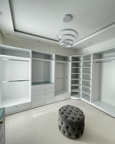 an empty room with white closets and lots of shelves on either side of the room