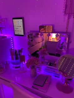 a bedroom with purple lighting and various items on the desk in front of the mirror