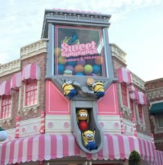 the front of a building with pink and white striped awnings on it's sides