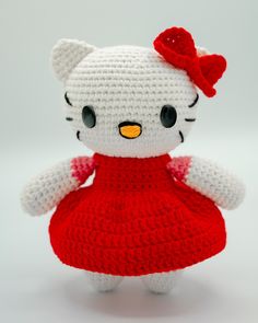 a crocheted hello kitty doll in a red dress