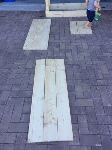 two children are playing with wooden planks on the ground in front of a building