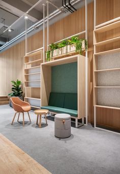 an office with wooden shelves and green plants on the wall, along with two chairs