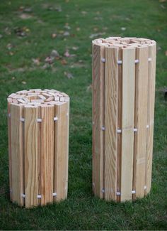 two wooden posts sitting in the grass near each other