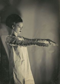 an old photo of a woman with her arm wrapped in duct tape and wearing gloves