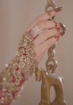 a close up of a person's hand with rings and bracelets on it