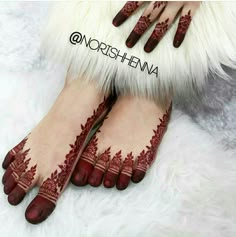 the feet and hands are decorated with hendi designs on them, while the toes are painted red