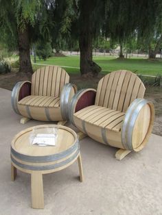 three wooden chairs sitting next to each other with barrels around them on top of cement