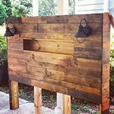 a wooden headboard with two black bells on it and some wood planks in the background