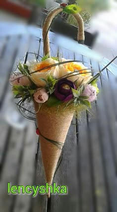 a flower arrangement in a cone on a wooden table with the words lencyshka written below it