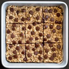 an oatmeal cookie with chocolate chips on top in a square white dish