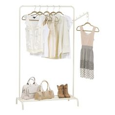 clothes and handbags are hanging on a white coat rack with two hangers holding purses