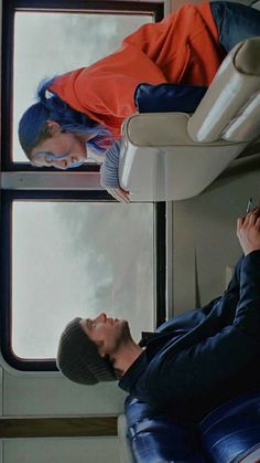 a man sitting on top of a train next to another person holding a cell phone