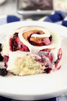 a piece of cake sitting on top of a white plate covered in icing and berries