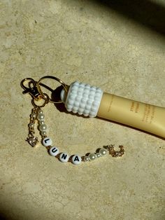 a close up of a toothbrush on a table with beads and keychain