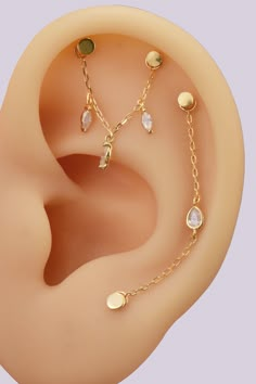 an ear with three different types of piercings on it's side, including a chain