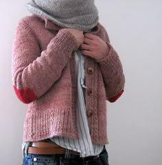 a woman wearing a pink cardigan and striped shirt is holding her hands on her hips