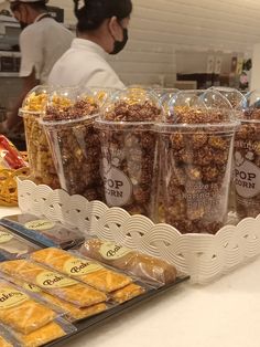 several bags of popcorn sitting on top of a counter next to other snacks and pastries