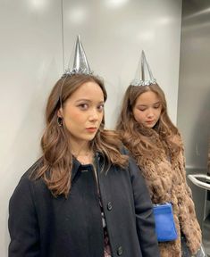 two young women wearing party hats standing next to each other