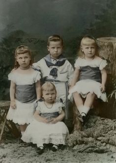 an old black and white photo of four children