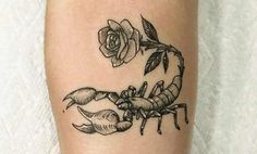 a small scorpion and rose tattoo on the right leg, with one flower in it's center