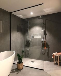 a bathroom with a bathtub, shower and plant in the corner on the floor