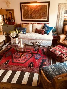 a living room filled with furniture and lots of pillows on top of it's rug