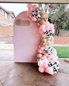 the balloon arch is decorated with cow balloons