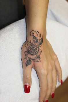 a woman's hand with a rose tattoo on it